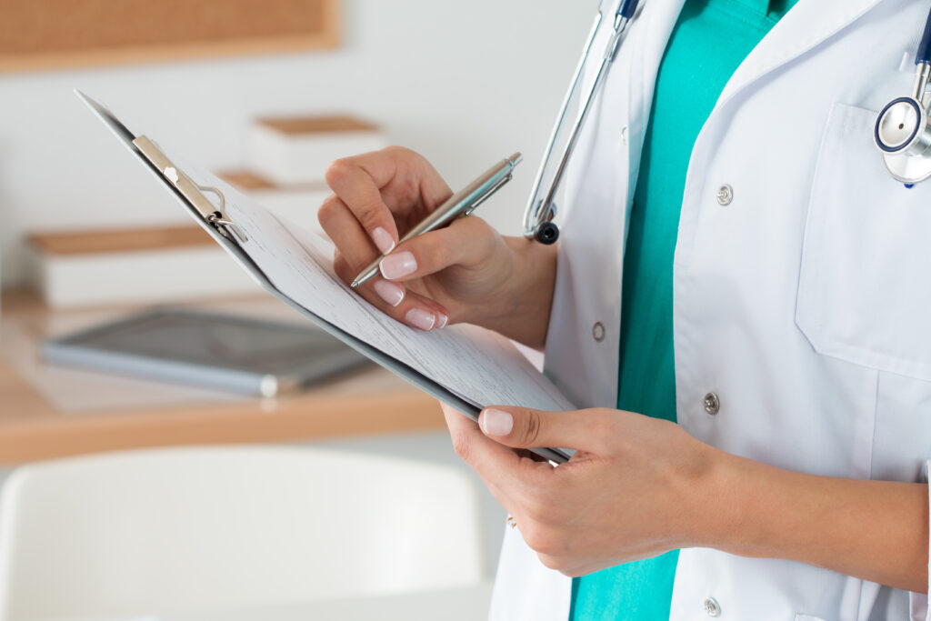 doctor writing notes on a clipboard