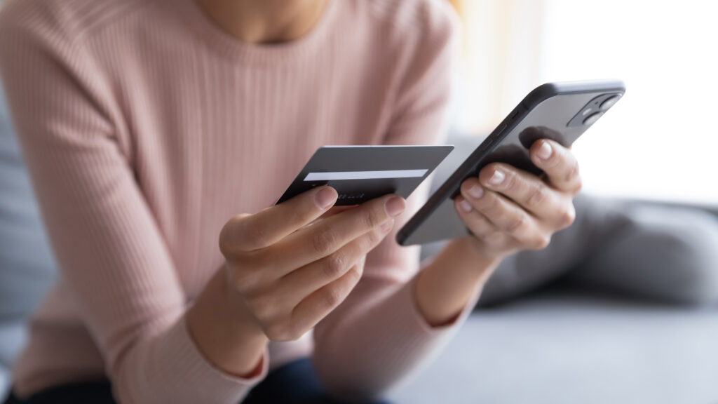 woman holding a credit card and iphone