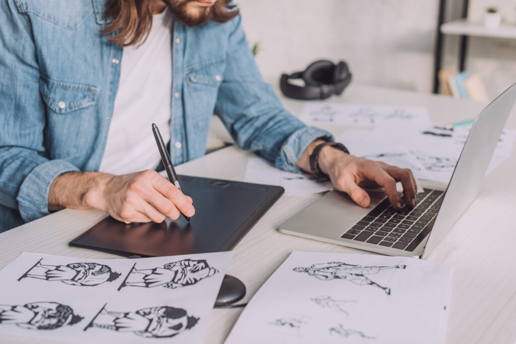 man sketching on a drawing tablet