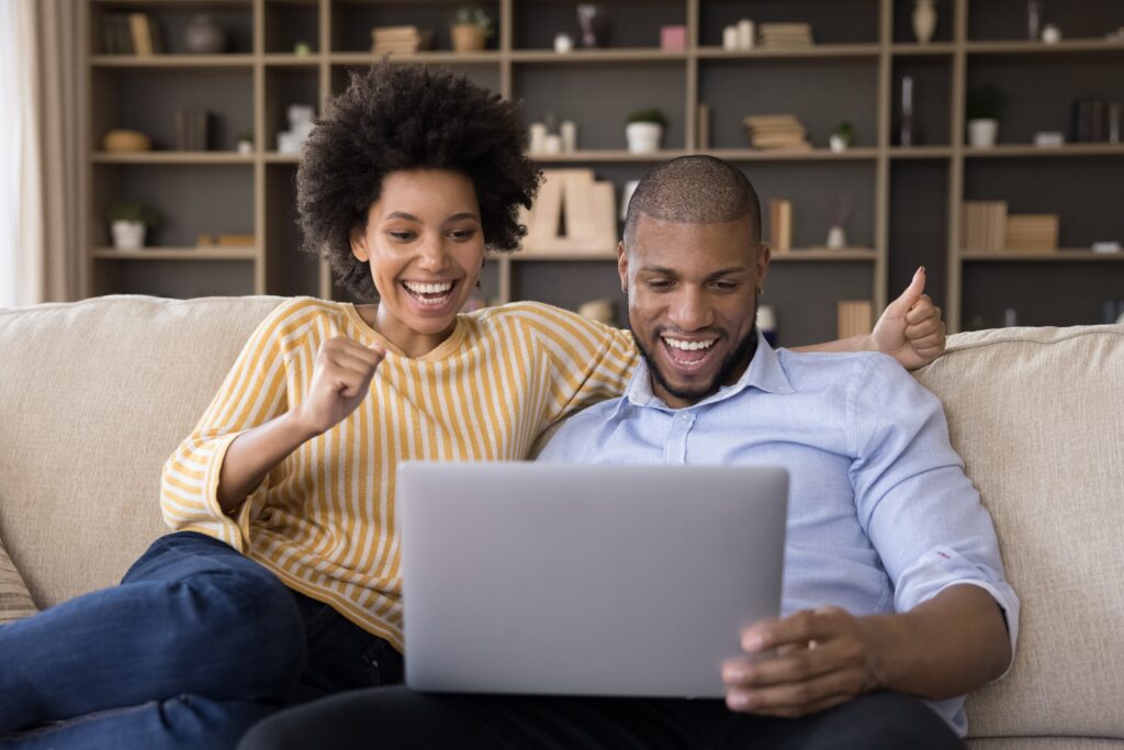 a couple excited to win a sweepstakes on their laptop