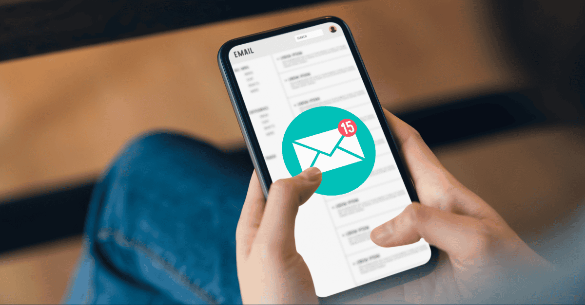 A person holding a smartphone displaying an email inbox with a notification badge showing 15 unread emails.